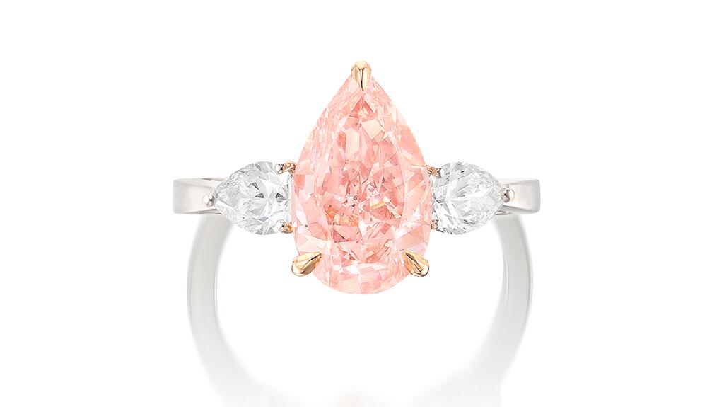 A nearly 3-carat pear-shaped fancy intense orangy pink diamond between two pear-shaped diamonds, mounted in white and pink gold fancy intense orangy pink diamond and diamond ring